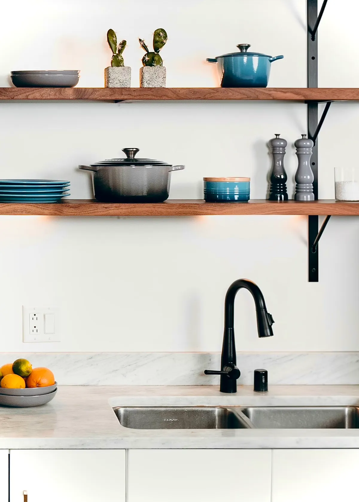 Open cottage kitchen shelves above a clean sink